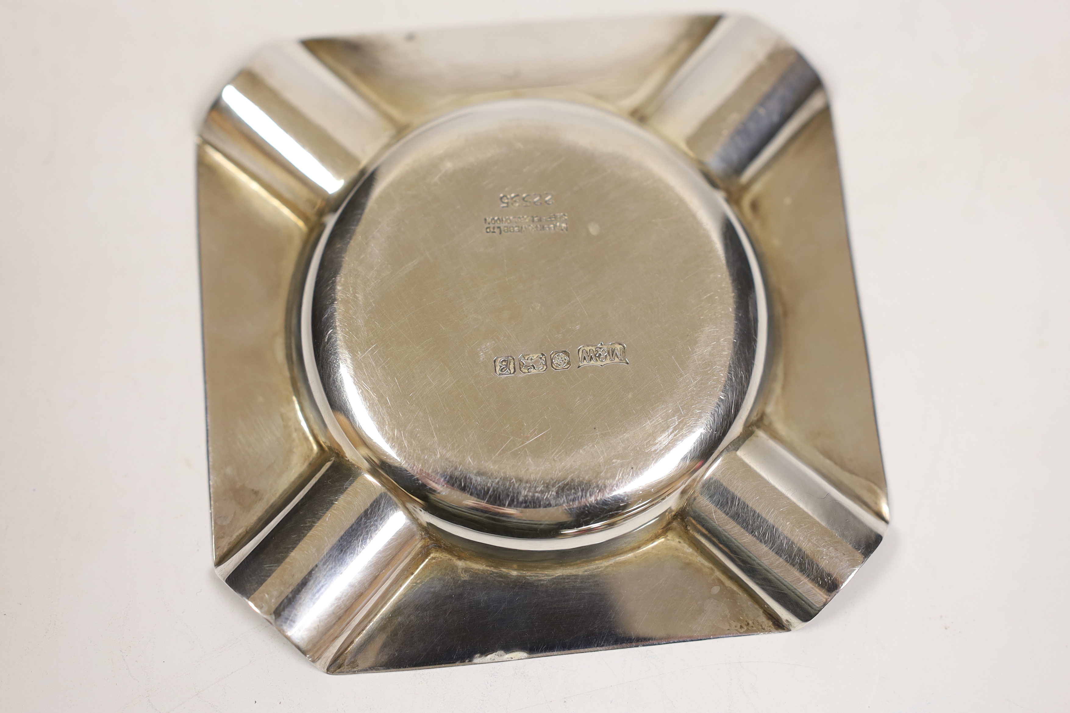 Three assorted silver ashtrays, including one engraved 'Officers Mess HQ UKLF', largest 10.1cm, together with a silver mounted cigar cutter.